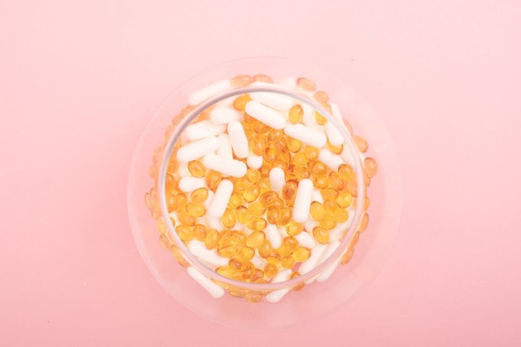 A bowl of cereal and marshmallows on top of pink table.